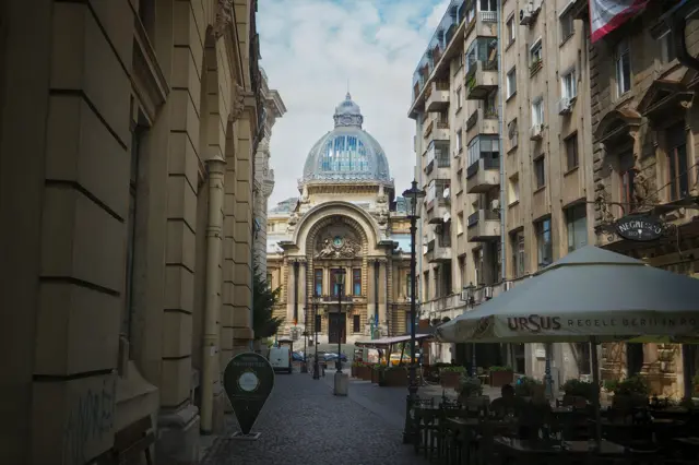 Le dôme de verre du palais CEC au bout d’une rue pavée de Bucarest